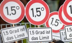 Bild på stopp-liknande runda protestskyltar där det står att 1.5°C är gränsen, anspelar på Parisavtalet och koldioxidutsläpp